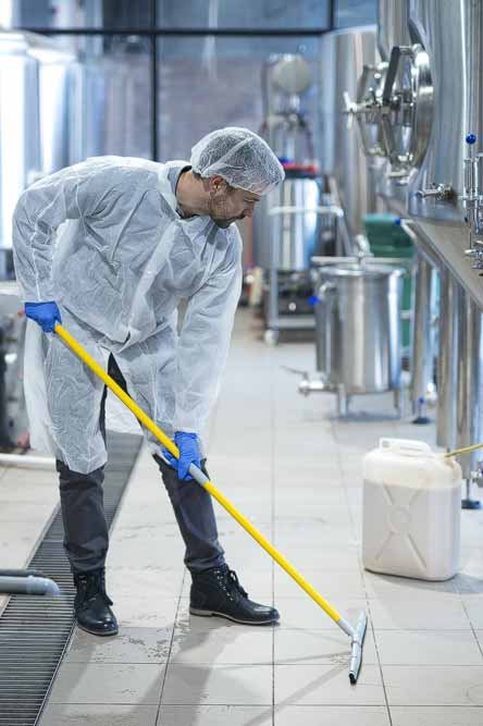 persona limpiando el piso de una fabrica