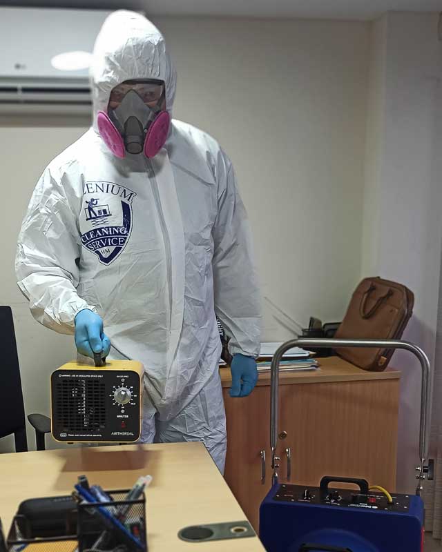 Persona con vestimenta de protección con aparato de genearación de ozono para desinfección